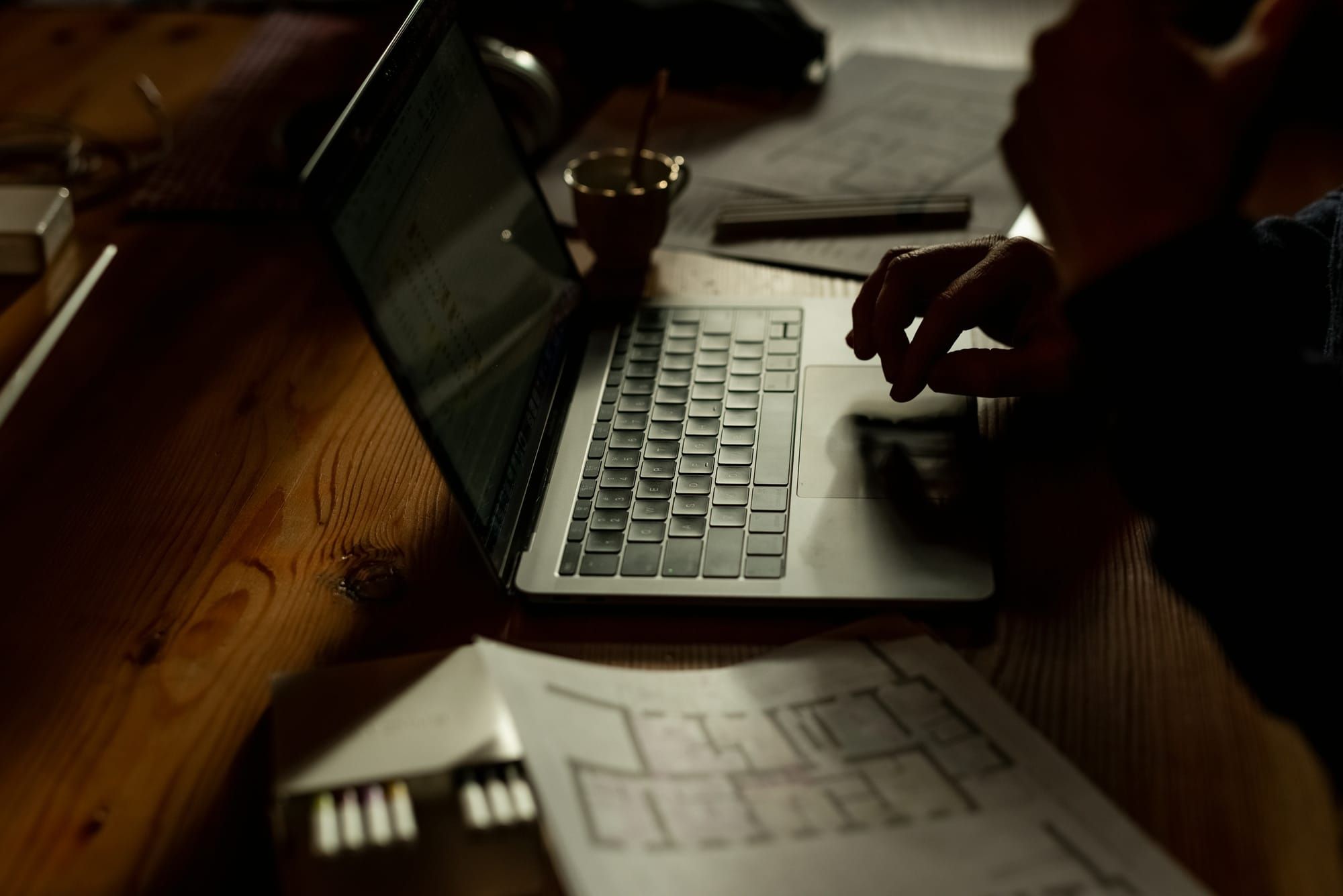 Laptop en bouwtekeningen op een houten werktafel
